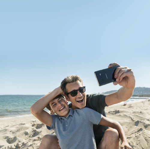 Campagne de publicité d'affichage boutique et PLV pour Bouygues Telecom produit à Nice montrant un père et son fils se prenant en selfie sur la plage avec un appareil Samsung
